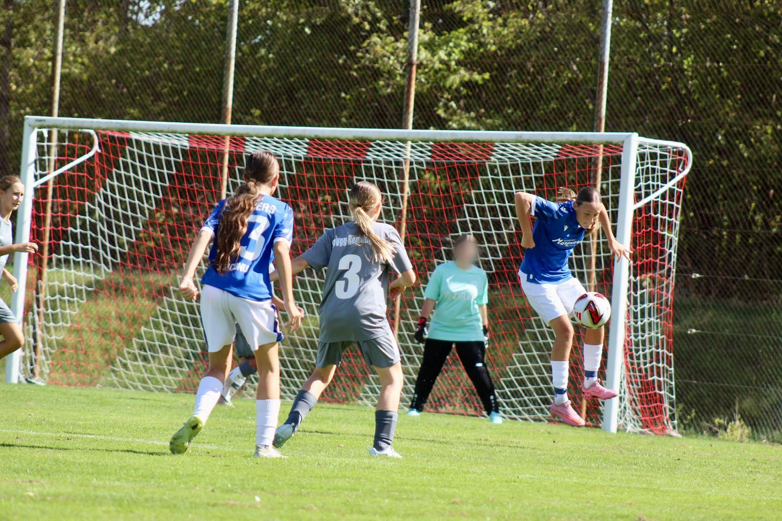 Spielerin des FC Panthers nimmt vor dem Tor den Ball mit dem Körper an, daneben eine Mitspielerin mit der Rückennummer 3 und eine Gegenspielerin in Grau, im Tor die Torhüterin.